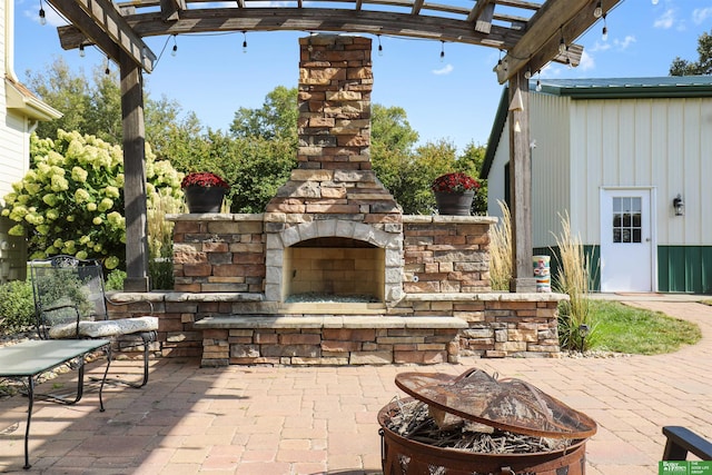 view of patio / terrace with a pergola, a fire pit, and an outdoor stone fireplace