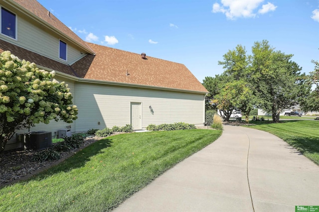 view of home's exterior with a yard and central air condition unit