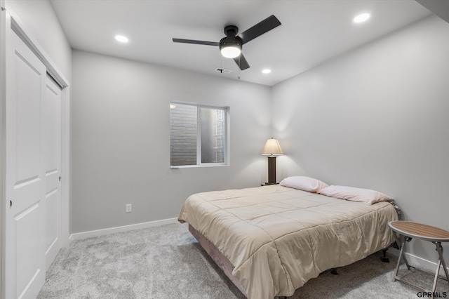 bedroom featuring light carpet, ceiling fan, and a closet