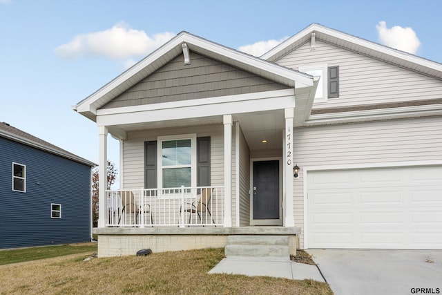 view of front facade with a garage, a front yard, and covered porch