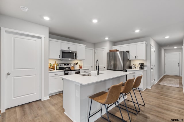 kitchen with white cabinetry, sink, a center island with sink, and appliances with stainless steel finishes