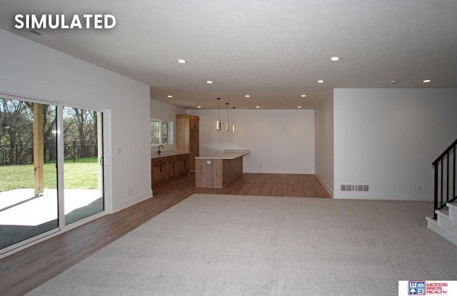 unfurnished living room with wood-type flooring and sink