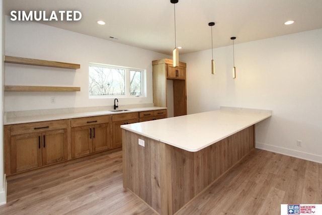 kitchen featuring sink, light hardwood / wood-style flooring, kitchen peninsula, and decorative light fixtures