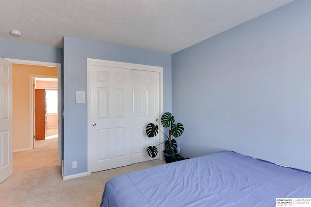 carpeted bedroom with a closet and a textured ceiling