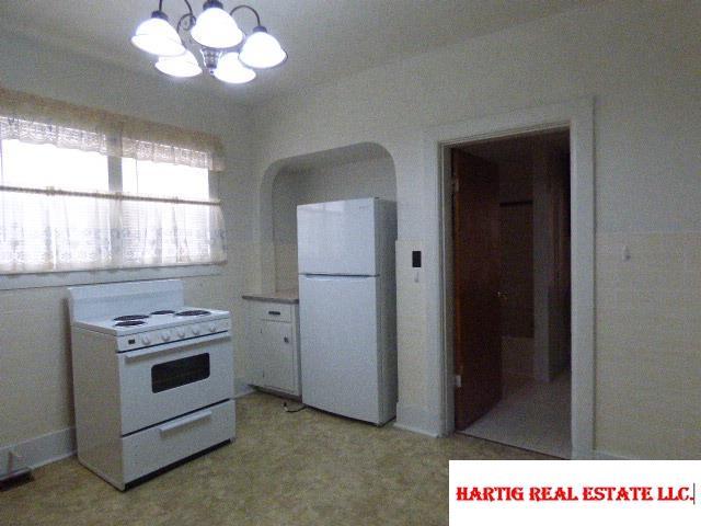 kitchen with white appliances and a chandelier