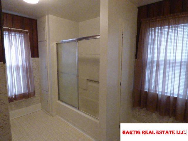 bathroom with combined bath / shower with glass door