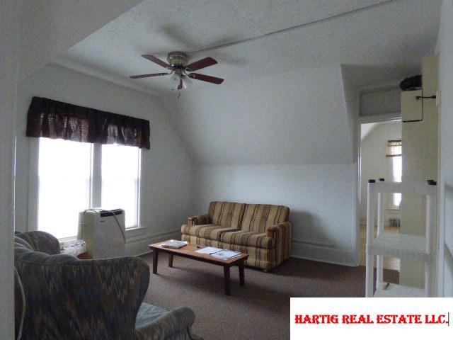 living room featuring ceiling fan and vaulted ceiling