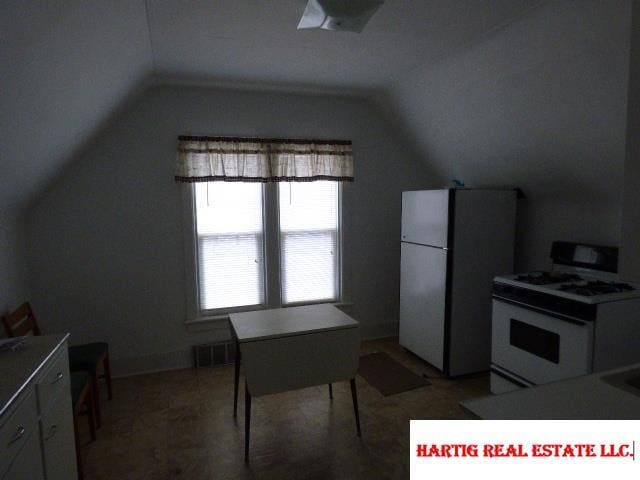 kitchen with white appliances and vaulted ceiling