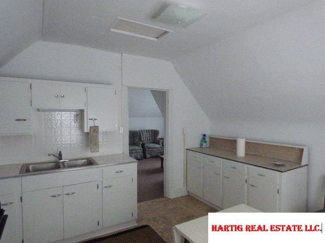 kitchen with white cabinetry, sink, and backsplash