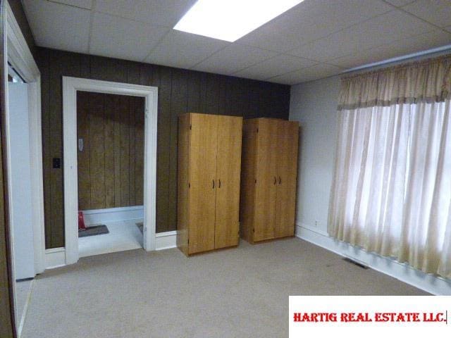 unfurnished bedroom featuring a drop ceiling