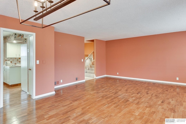 empty room featuring light hardwood / wood-style flooring and a textured ceiling