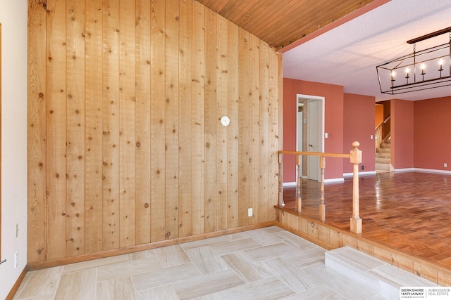 unfurnished room featuring wooden walls