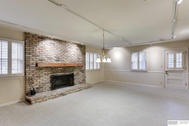 unfurnished living room with track lighting and a fireplace