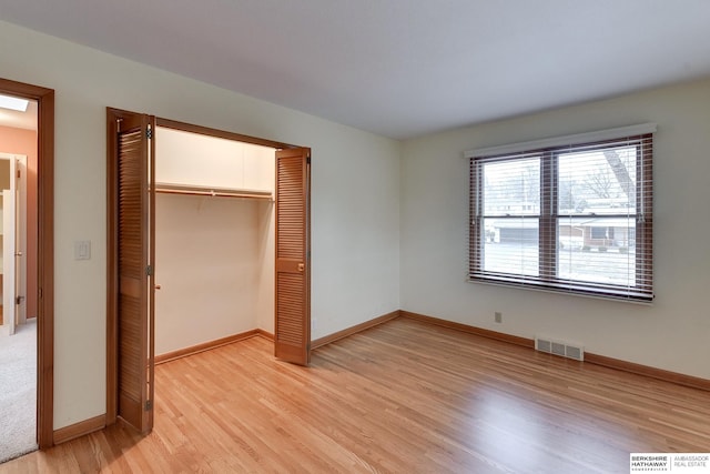 unfurnished bedroom with a closet and light hardwood / wood-style flooring