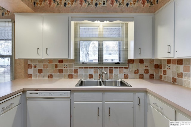 kitchen featuring white cabinetry, dishwasher, sink, and tasteful backsplash