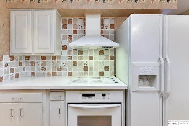 kitchen with tasteful backsplash, white appliances, wall chimney exhaust hood, and white cabinets