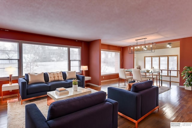 living room featuring an inviting chandelier, hardwood / wood-style flooring, and plenty of natural light