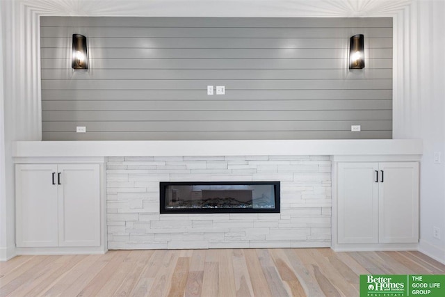 room details featuring a stone fireplace and hardwood / wood-style floors