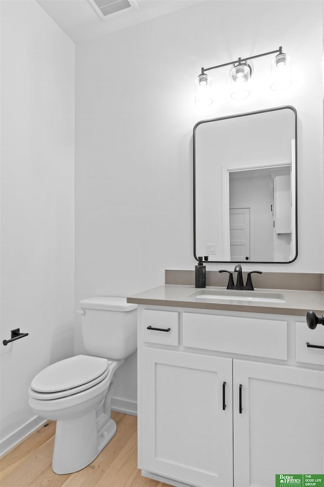 bathroom with vanity, hardwood / wood-style flooring, and toilet