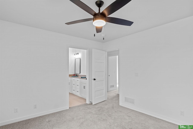 unfurnished bedroom featuring light carpet, ceiling fan, and ensuite bathroom