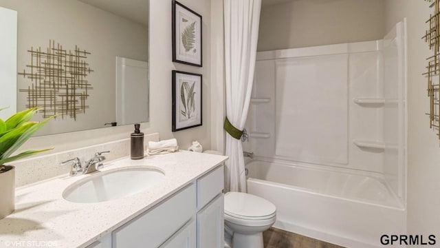 full bathroom featuring vanity, shower / bath combination with curtain, and toilet