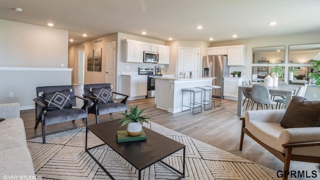 living room featuring sink and light hardwood / wood-style flooring