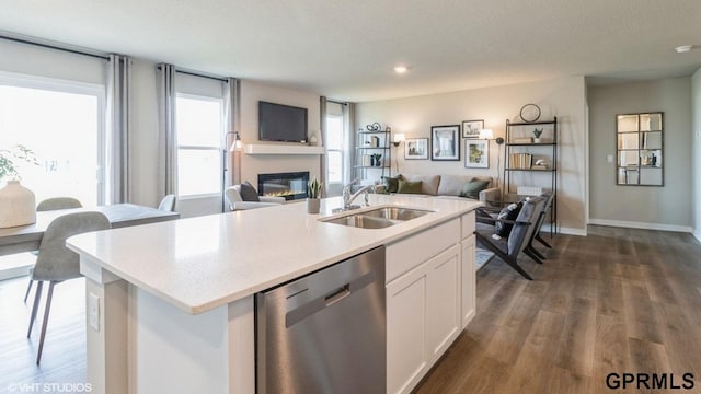 kitchen with sink, stainless steel dishwasher, dark hardwood / wood-style floors, a kitchen island with sink, and white cabinets