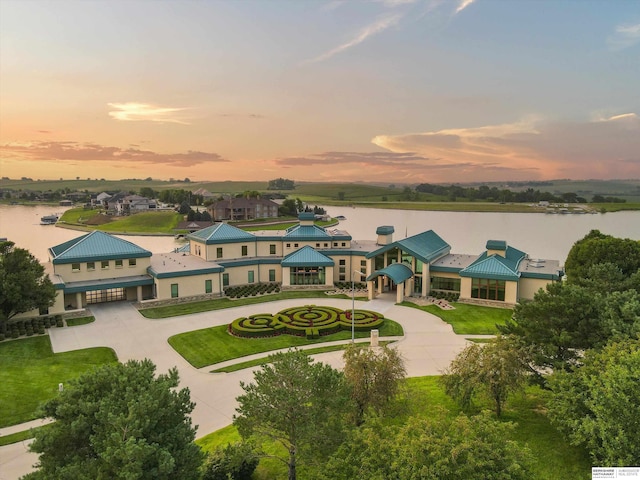 aerial view at dusk featuring a water view