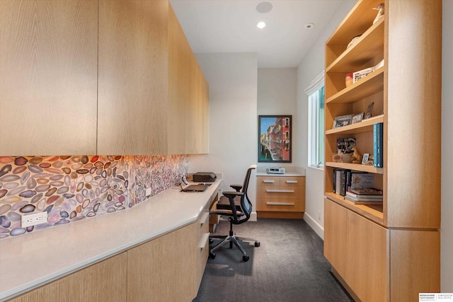 office area featuring built in desk and dark colored carpet