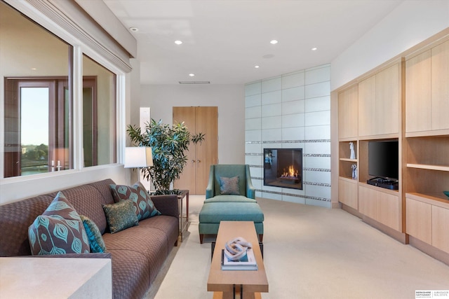 living room featuring light carpet and a fireplace