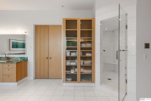 bathroom featuring a shower with door, vanity, and tile patterned floors