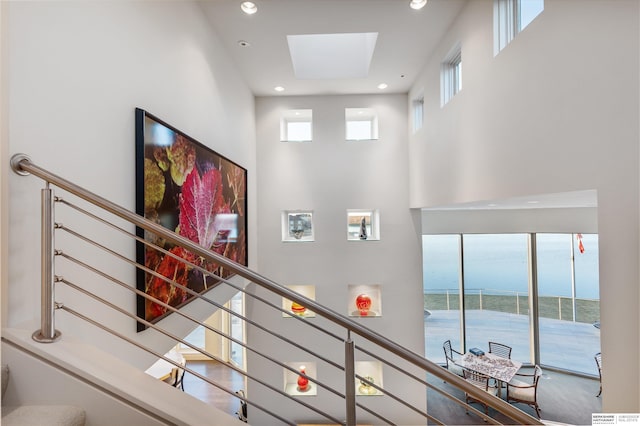 stairway with a high ceiling and a water view