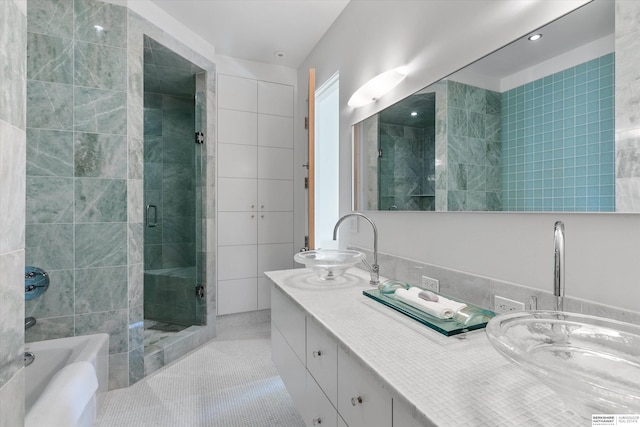 bathroom featuring vanity, tile patterned floors, independent shower and bath, and tile walls