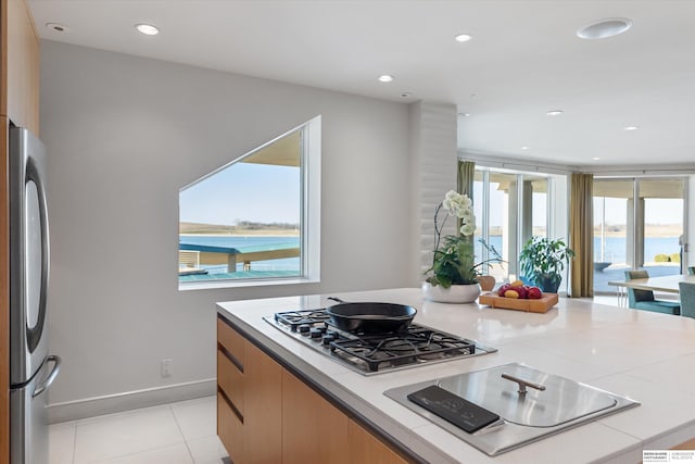 kitchen with a water view, stainless steel appliances, and light tile patterned floors