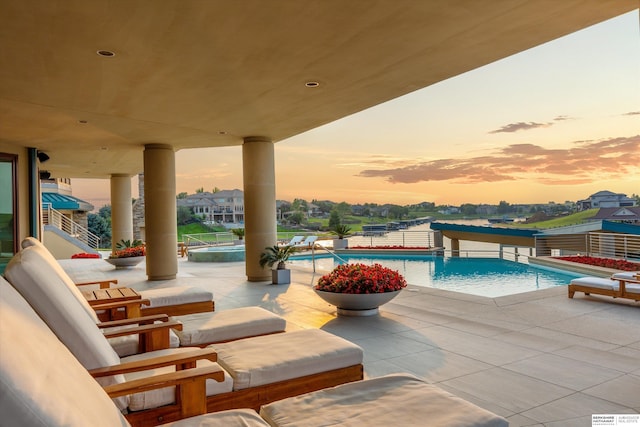 pool at dusk with a patio