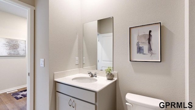 bathroom with vanity, wood-type flooring, and toilet