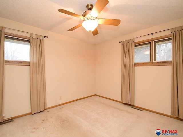 unfurnished room featuring ceiling fan, carpet floors, and a textured ceiling