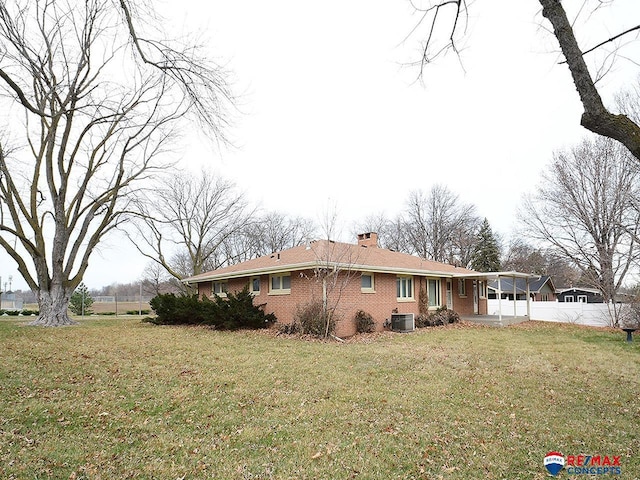 view of side of home with central AC and a lawn