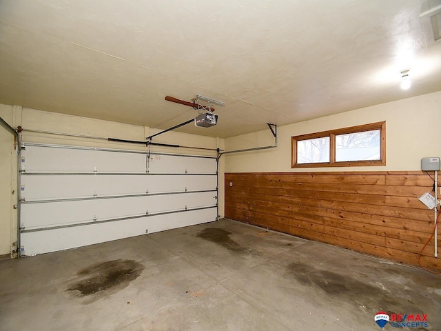 garage featuring a garage door opener and wooden walls