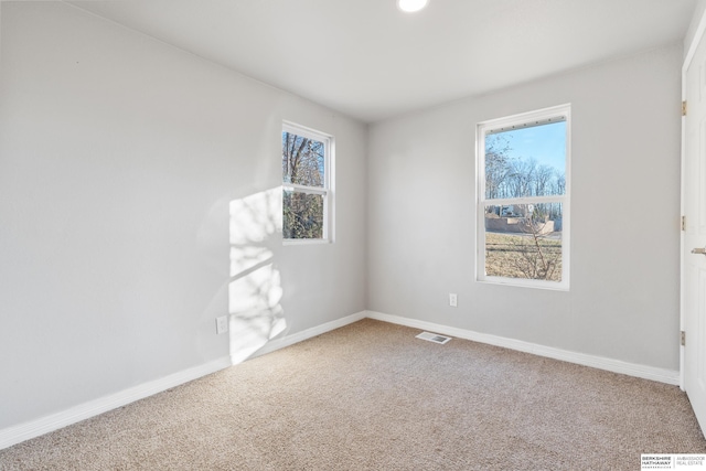 unfurnished room with plenty of natural light and carpet floors