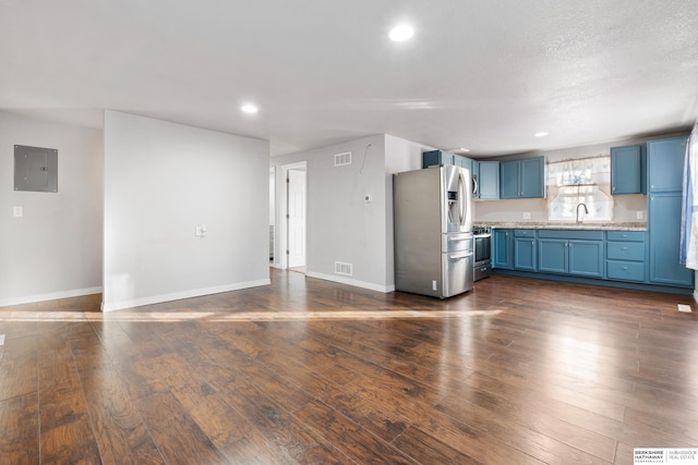 unfurnished living room featuring sink, electric panel, dark hardwood / wood-style floors, and a textured ceiling