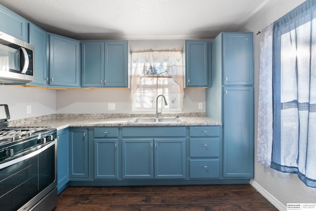 kitchen featuring sink, stainless steel appliances, and blue cabinets