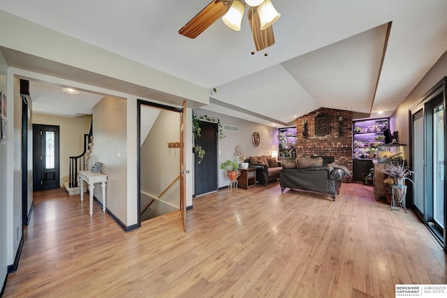 living room featuring ceiling fan, vaulted ceiling, and light wood-type flooring