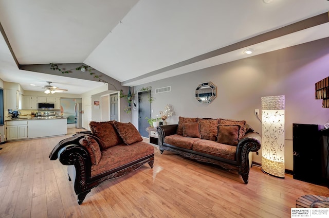 living room featuring vaulted ceiling, light hardwood / wood-style floors, and ceiling fan