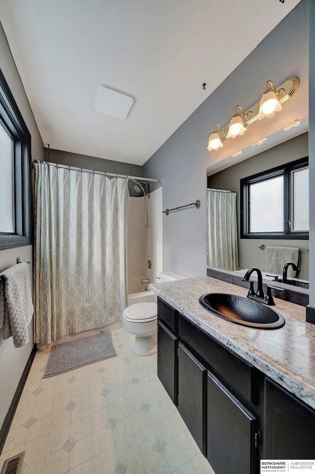 full bathroom with shower / bathtub combination with curtain, vanity, and toilet