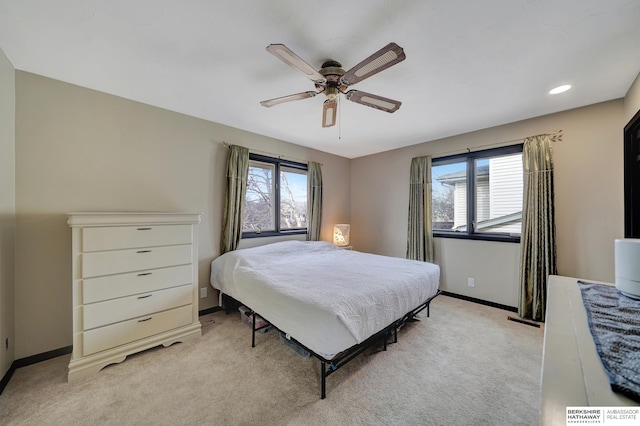 carpeted bedroom with ceiling fan and multiple windows