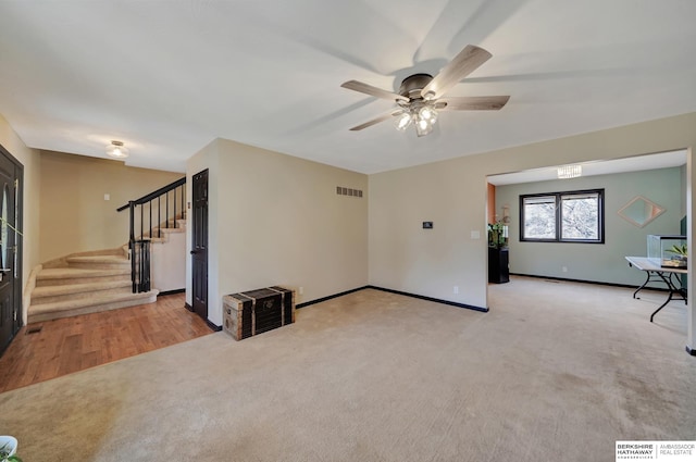 unfurnished living room featuring ceiling fan and light colored carpet