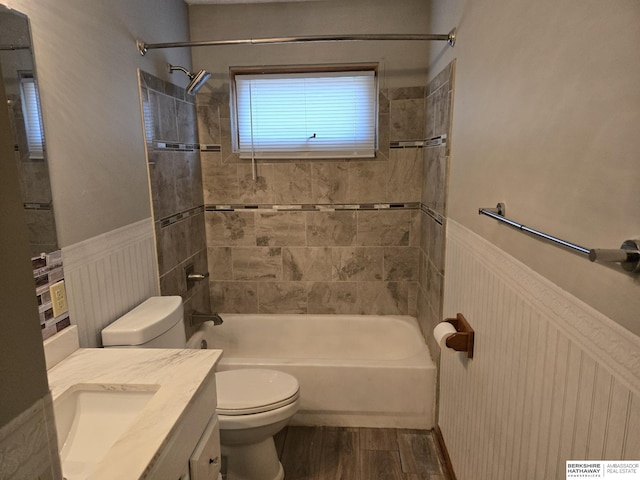 full bathroom featuring wood-type flooring, toilet, tiled shower / bath combo, and vanity