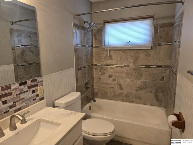 full bathroom with tiled shower / bath, vanity, and toilet