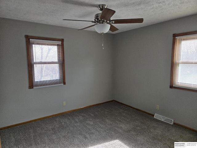 carpeted spare room with ceiling fan and a textured ceiling